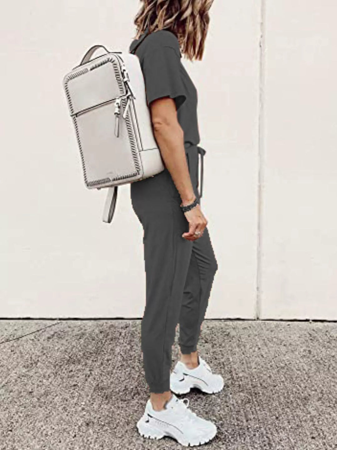Charcoal tee and jogger pants from the side with a white backpack