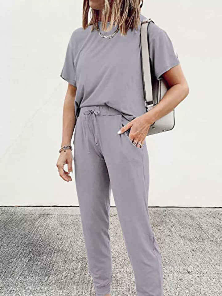 Lilac gray tee and joggers worn with a white bag on the arm