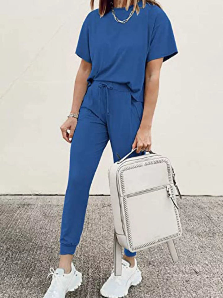 Royal blue lounge set styled while holding a white backpack by the handle
