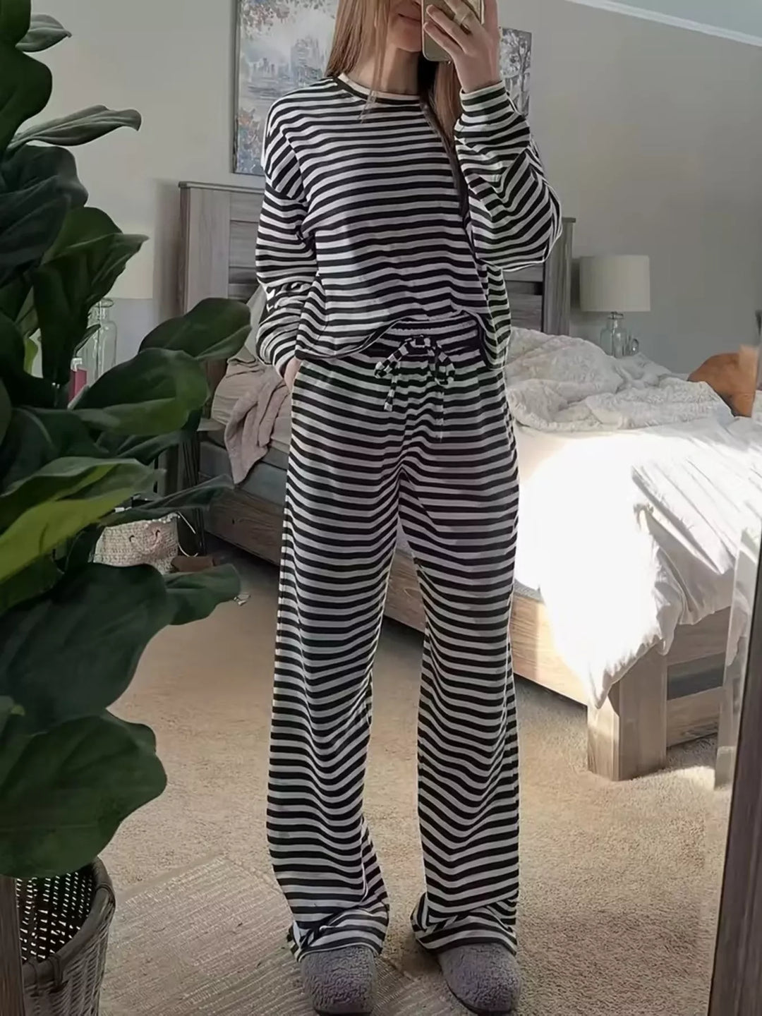 Black striped long sleeve top and wide leg pants, full length on a wood floor