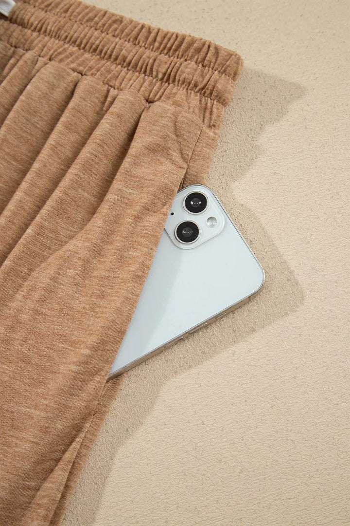 Side pocket of the camel lounge pants holding a phone