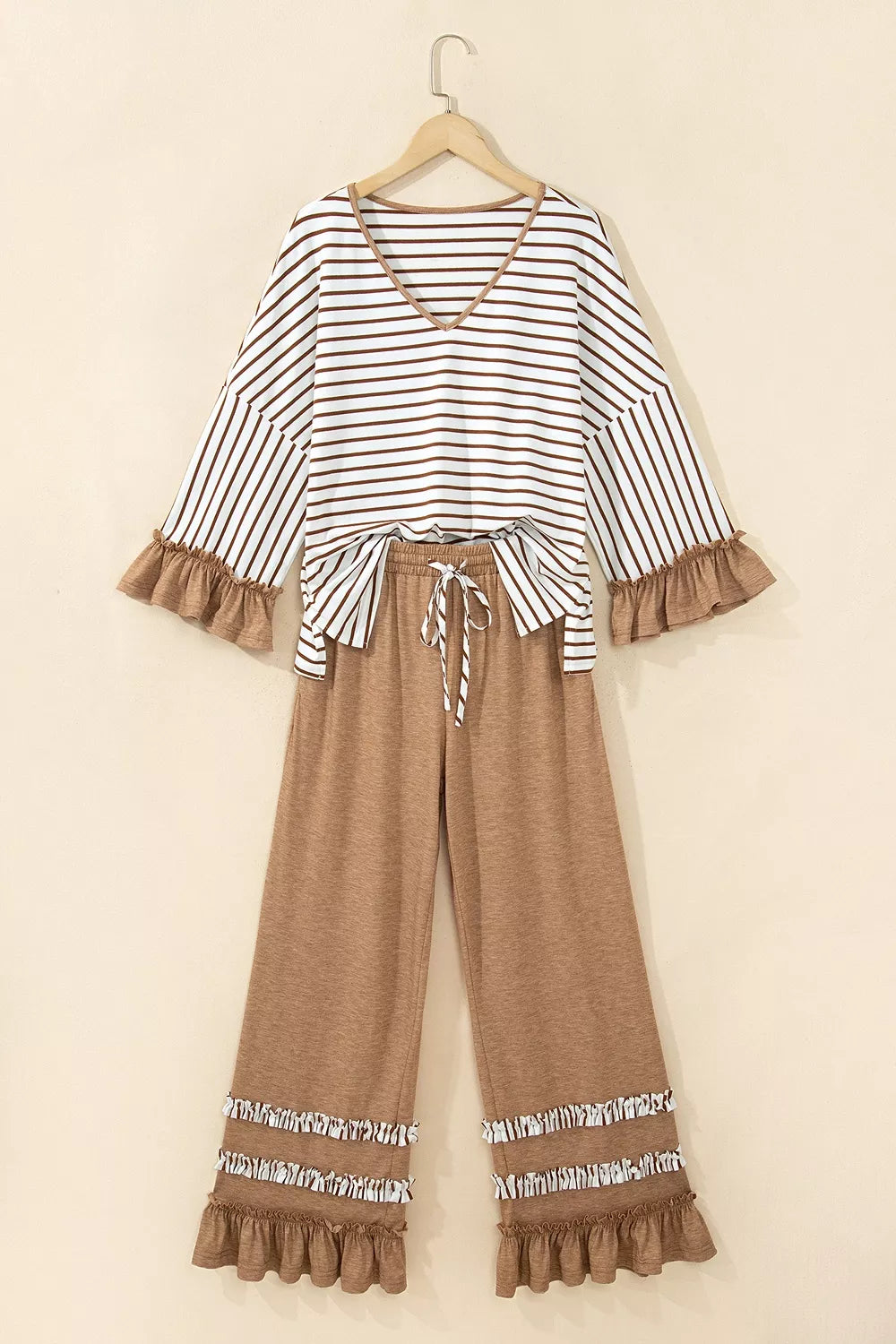 Striped V neck top and camel wide leg pants hanging together, front view
