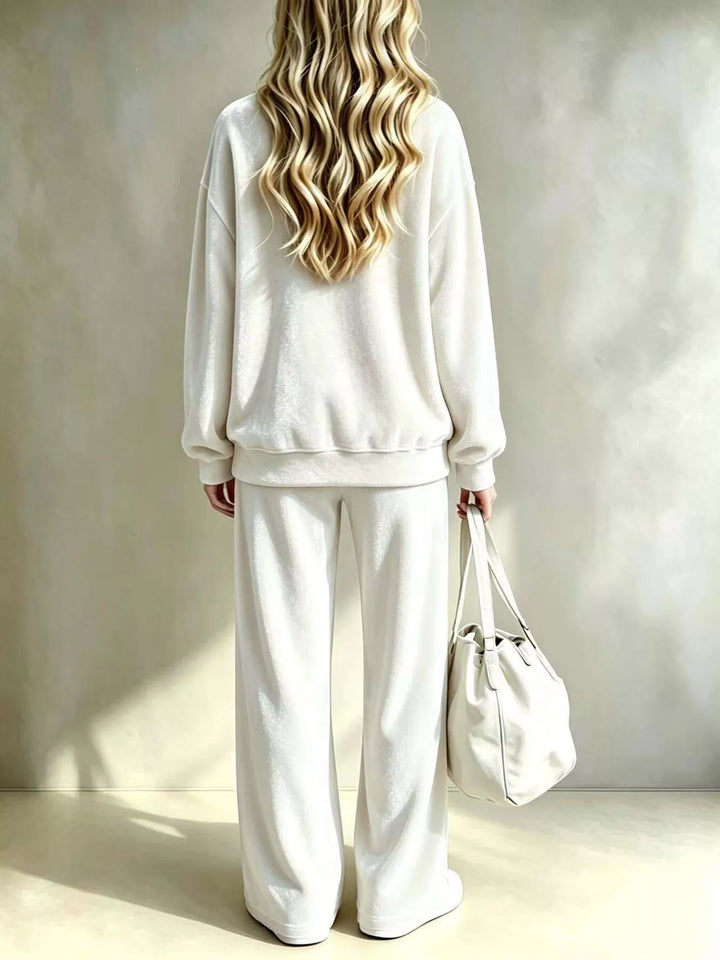 Ivory lounge set seen from behind with the wide leg pants and white tote bag