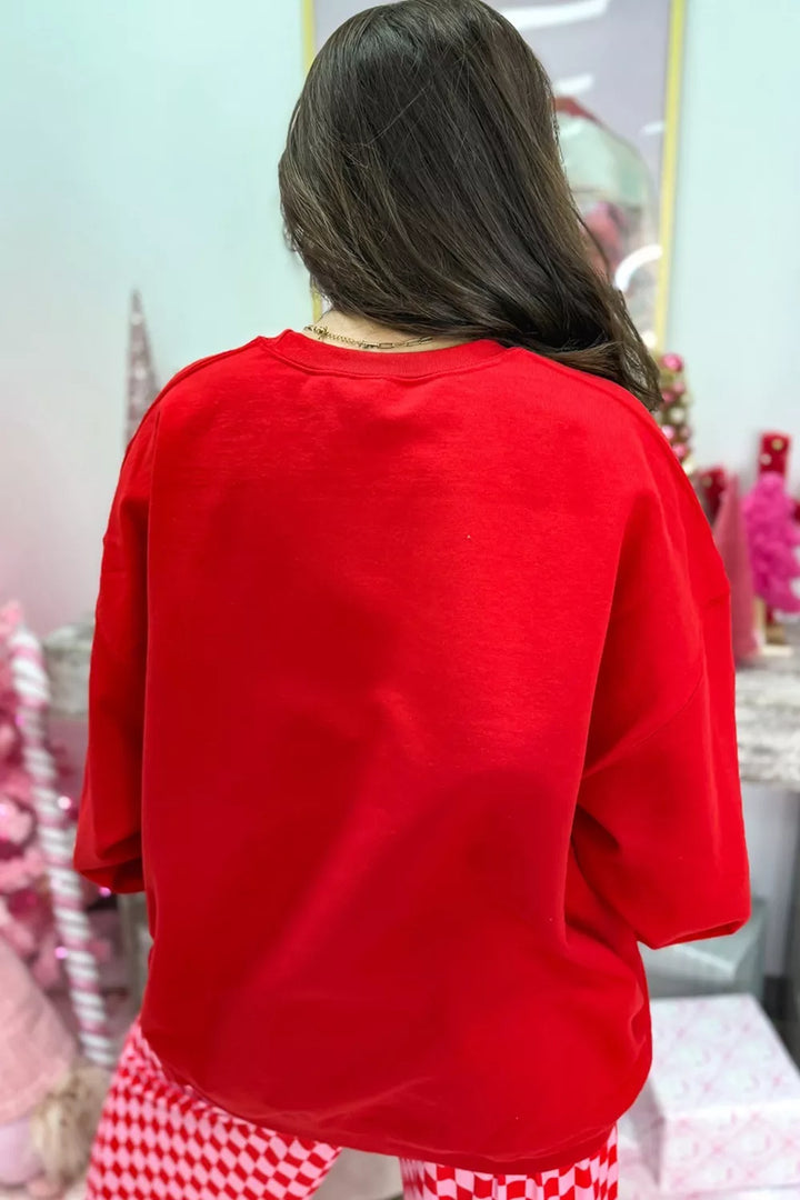 Back view of the red oversized sweatshirt with checkered wide leg pants