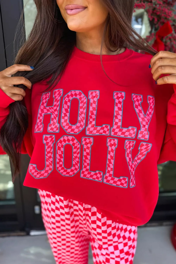 Close-up of the red Holly Jolly sweatshirt lettering with pink checkered pants