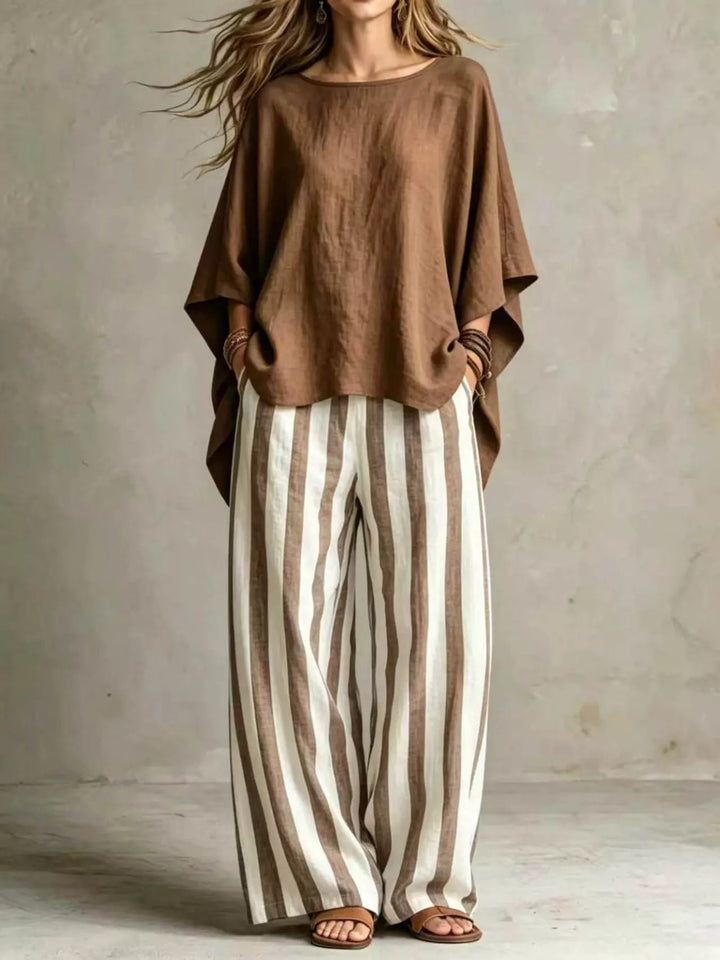 Brown batwing top paired with striped wide leg pants, full length view