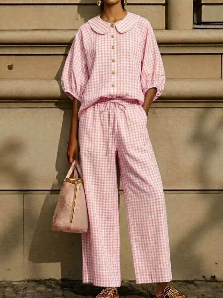 pink gingham top and wide leg pants set with drawstring waist, holding a bag