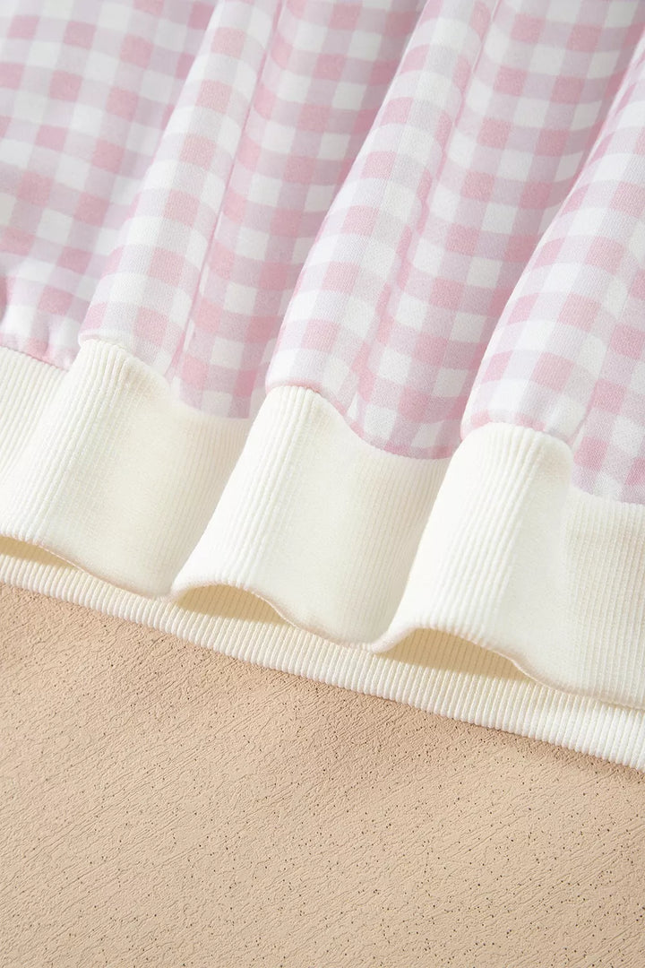 Close-up of the ribbed hem on the blush pink gingham sweatshirt