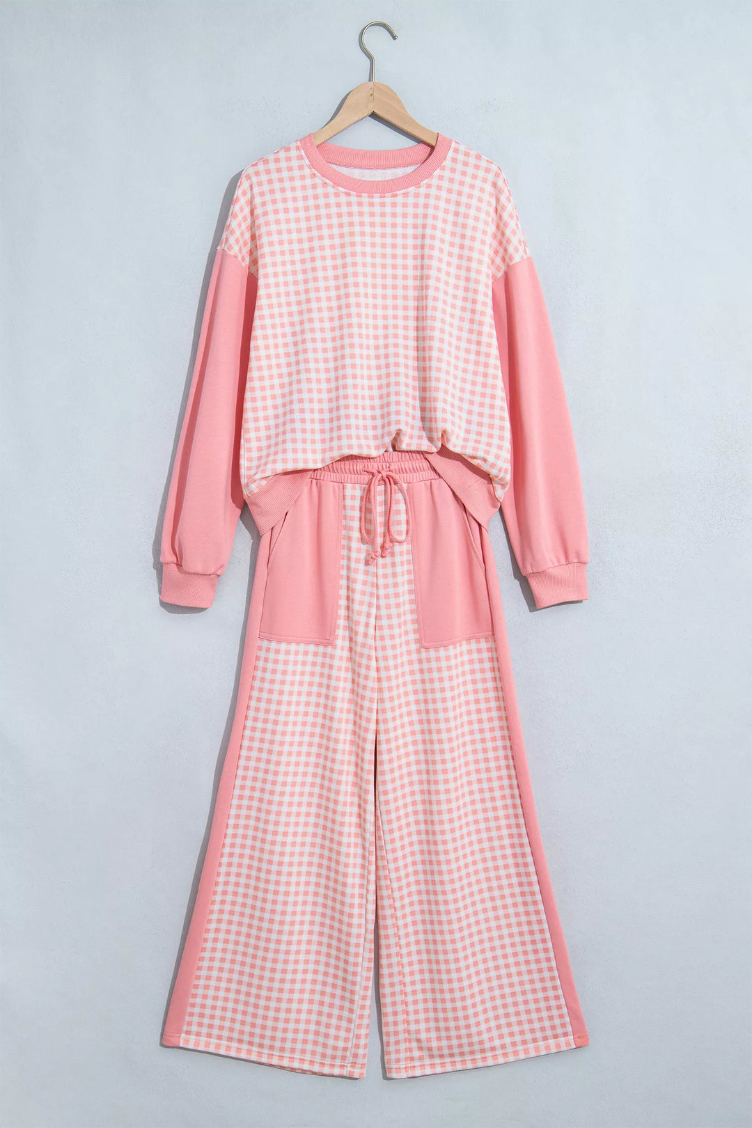 Coral pink gingham sweatshirt and wide leg pants hanging flat, drawstring waist