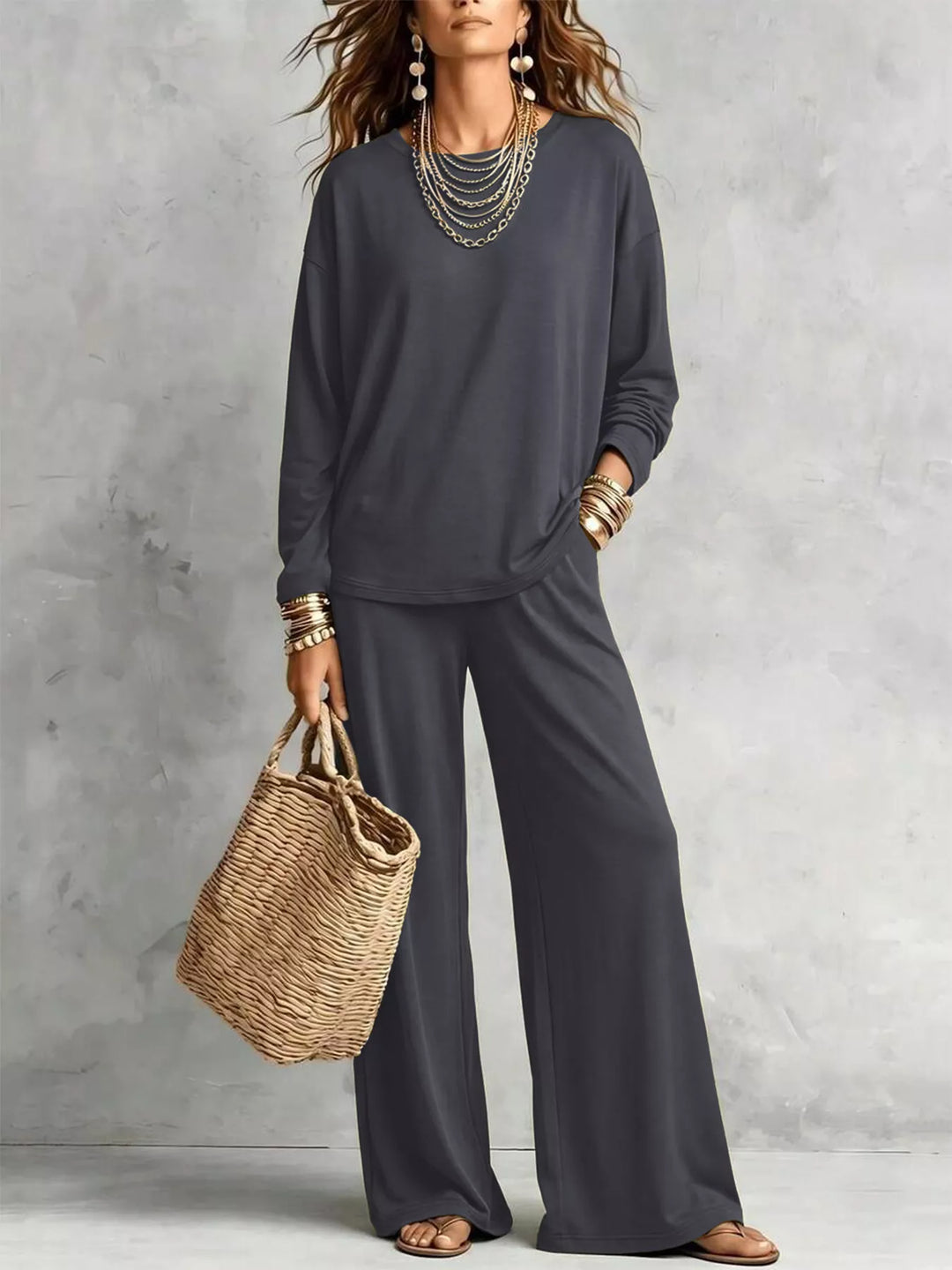 Charcoal long sleeve tee and wide leg pants set carrying a woven bag