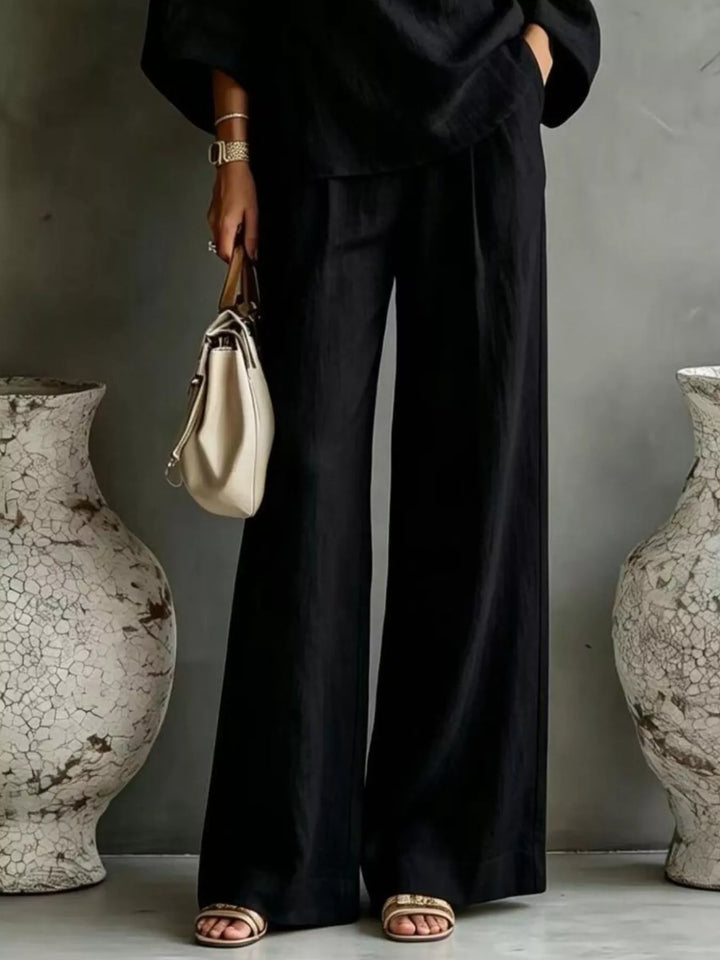 Black wide leg pants and top set worn with a cream handbag