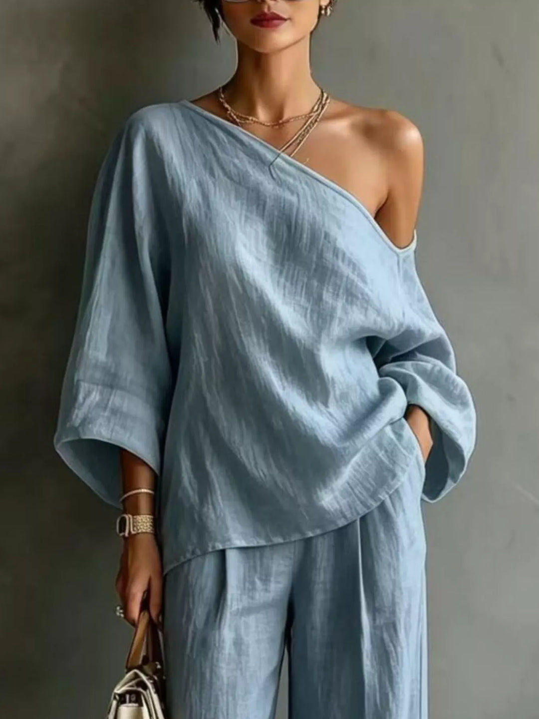 Close-up of the light blue one shoulder top with batwing sleeves