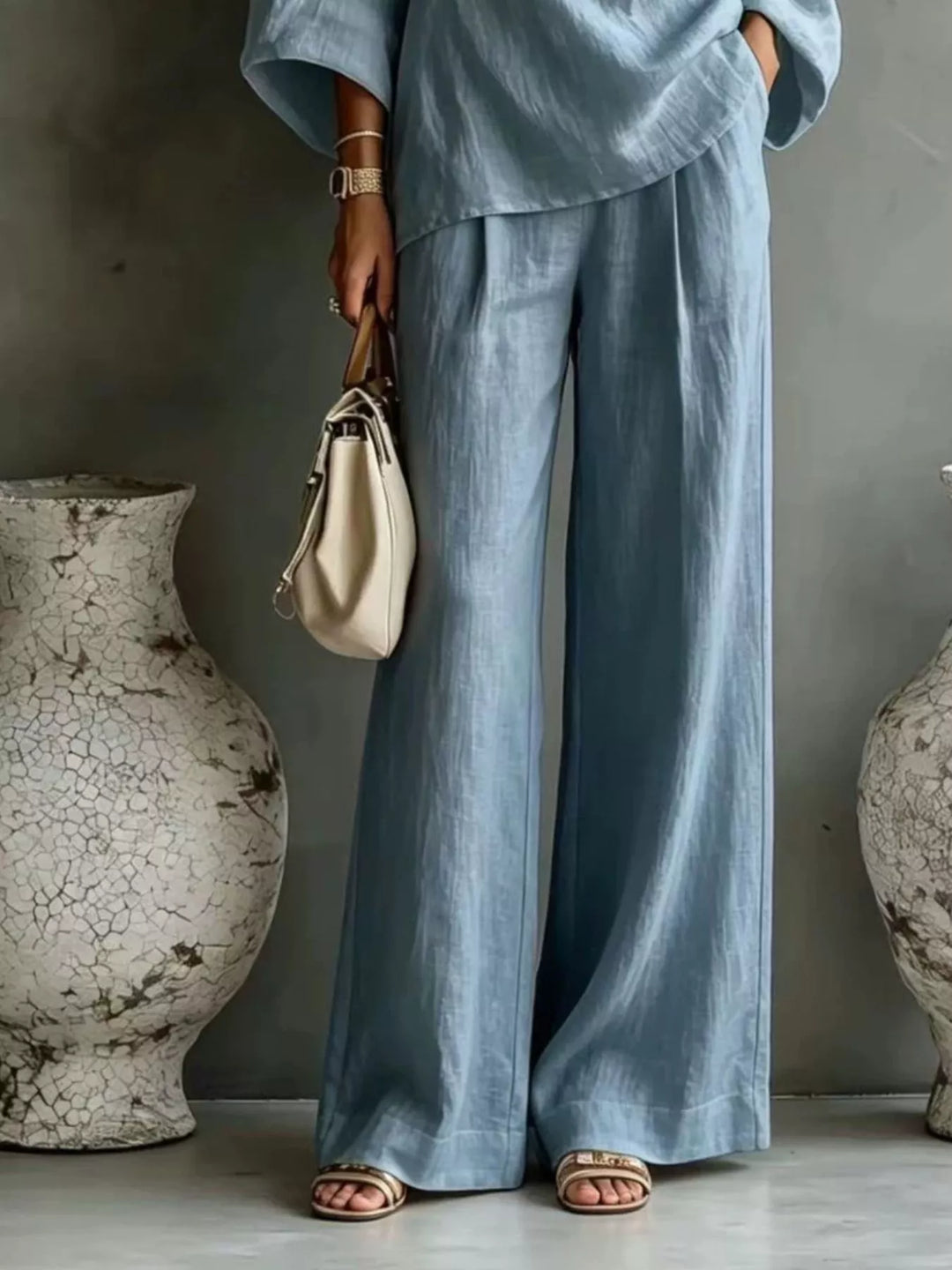 Light blue wide leg pants and top set worn with a cream handbag