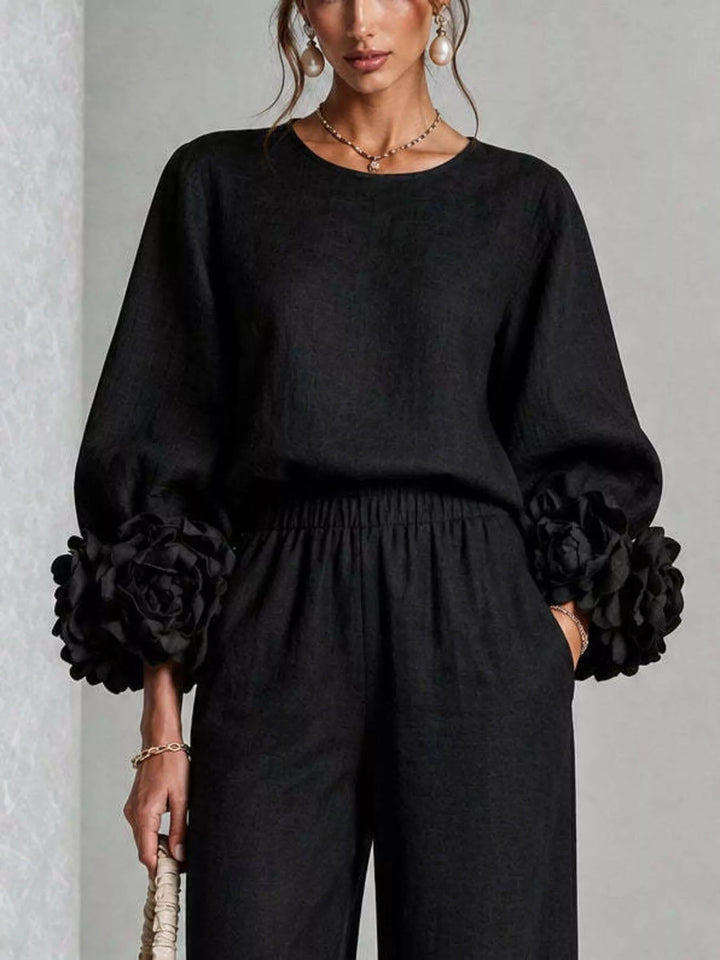 Close-up of the black puff sleeve top with ruffled cuffs