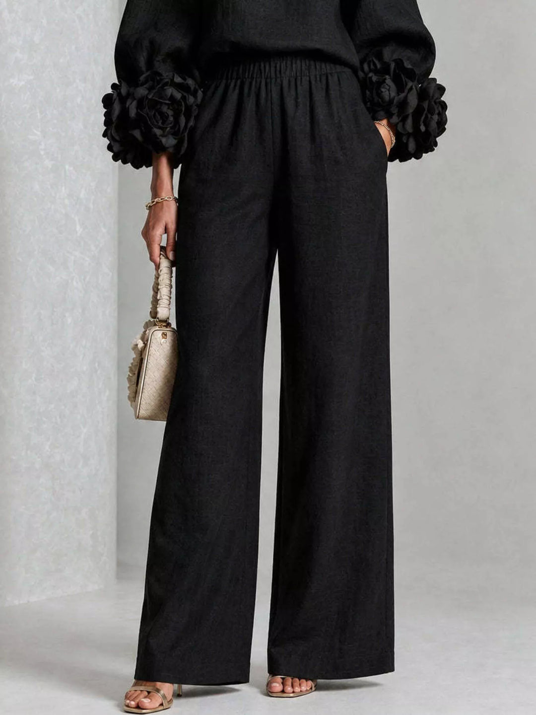 Detail of the black wide leg pants with pockets and gathered cuffs