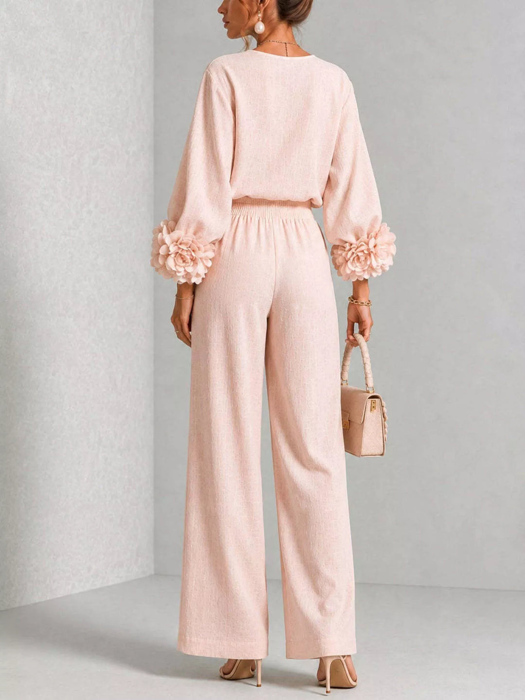 Blush pink puff sleeve top and pants set in a turned three-quarter view