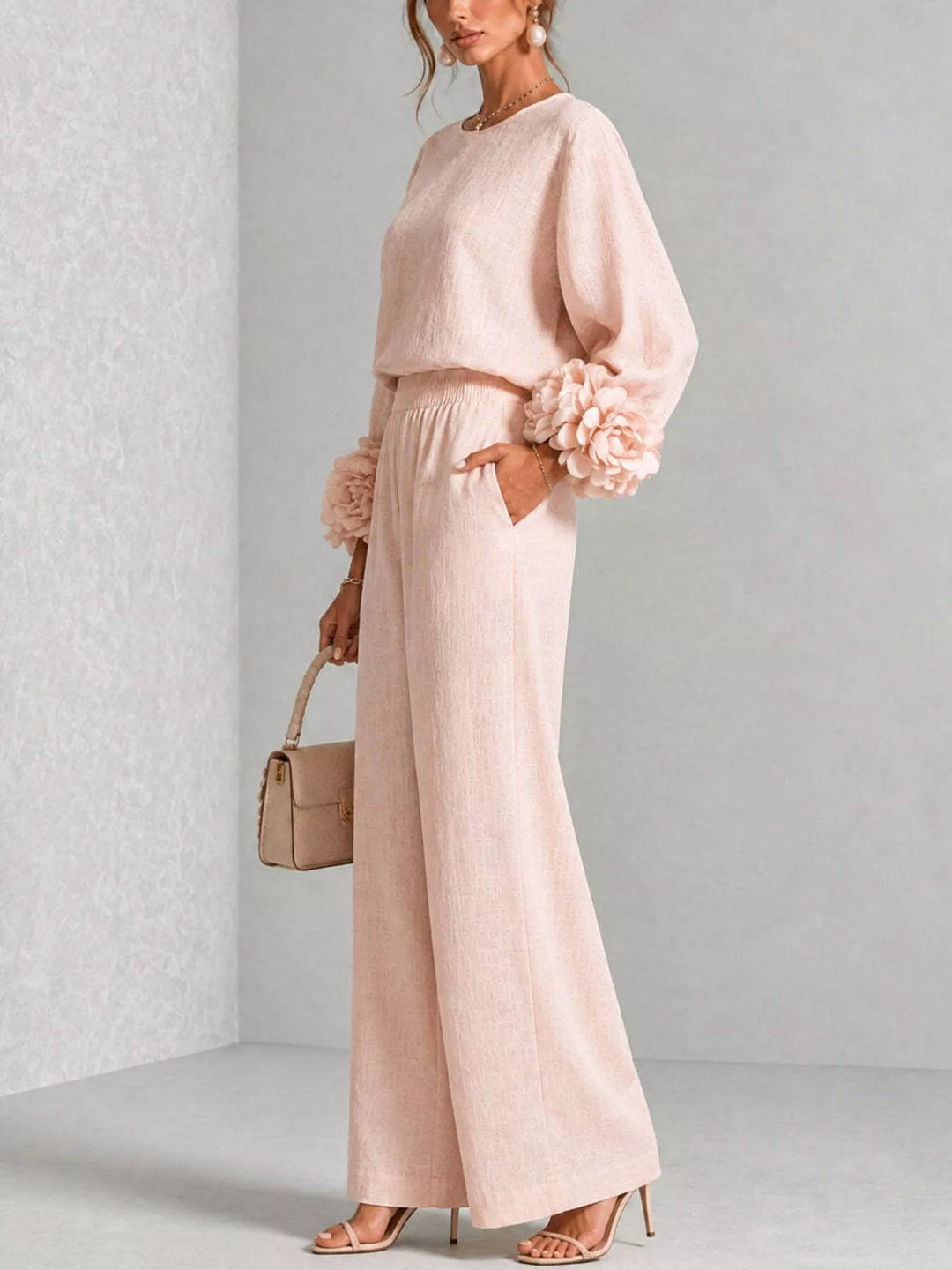 Side view of the blush pink matching set holding a small handbag