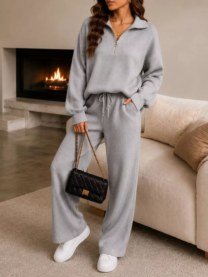 Light gray half zip pullover and wide leg pants set, front view with a bag
