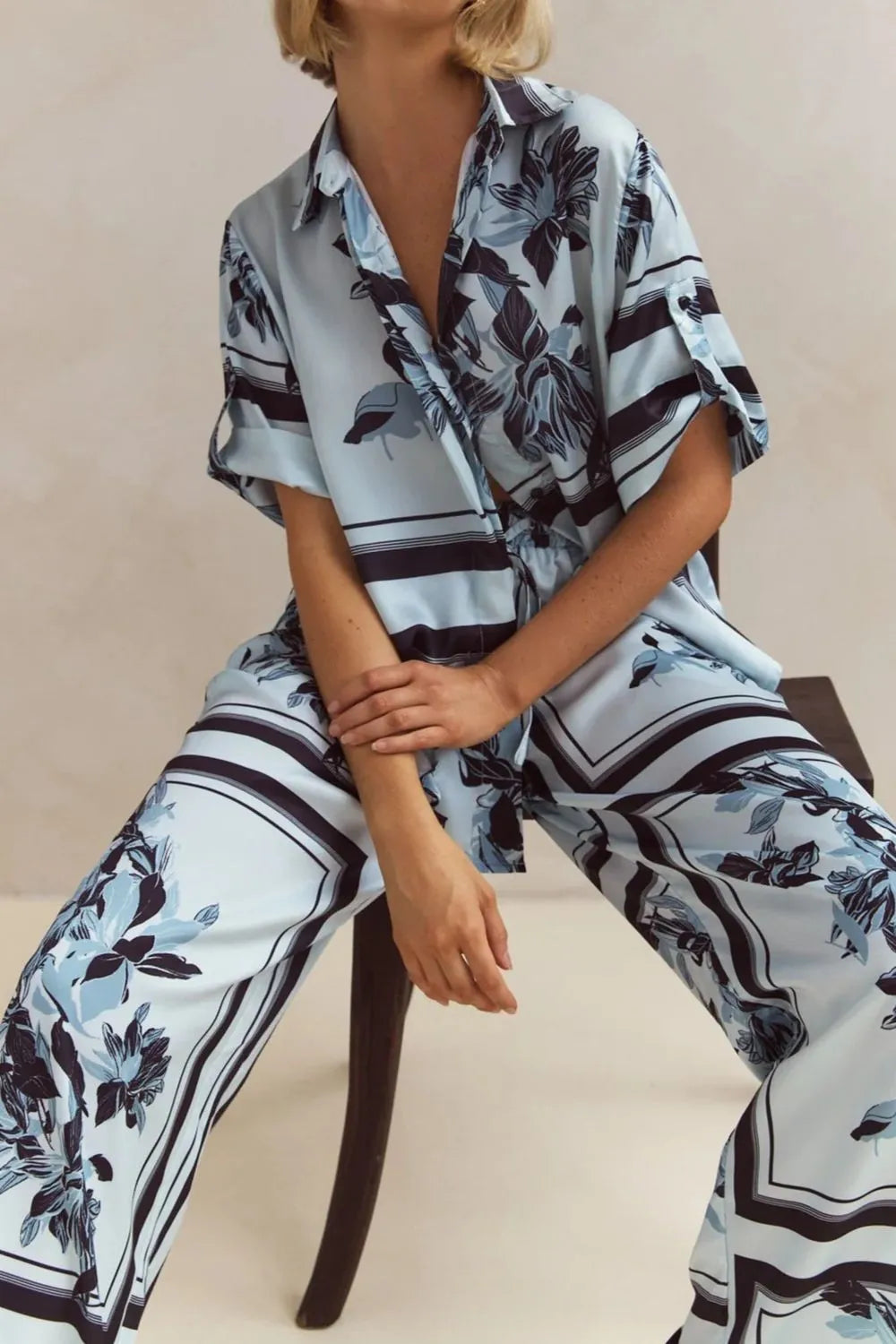 Sky blue print set worn seated on a stool, showing the relaxed pants