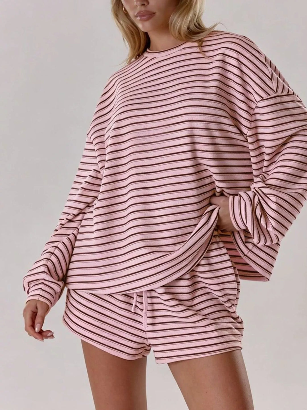 Striped long sleeve top and drawstring shorts in pink, styled on model