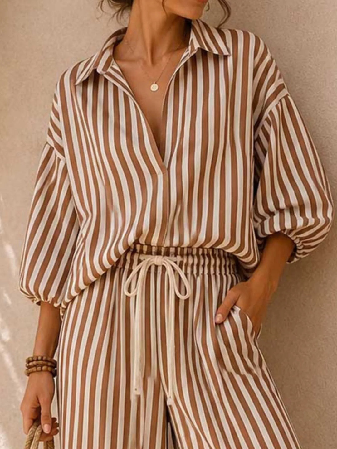 Close-up of the brown striped shirt with open collar and balloon sleeves