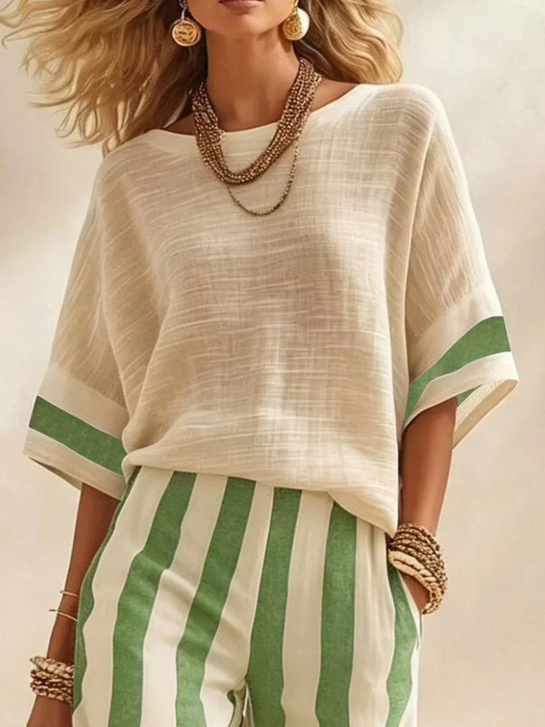 Close-up of the cream top with green sleeve trim over green striped pants