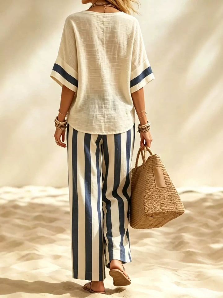 Back view of the navy striped matching set walking on sand