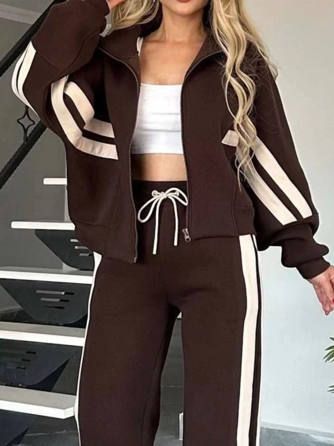 Close-up of the chocolate brown zip jacket with striped sleeves and drawstring waist