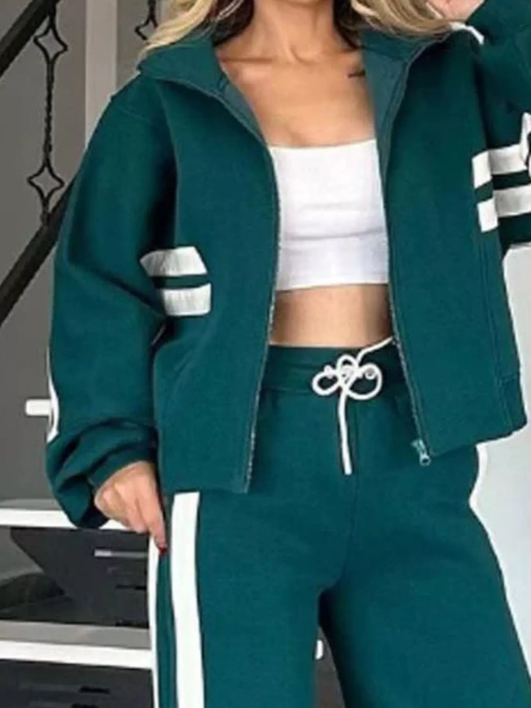Close-up of the teal zip up jacket with white sleeve stripes and drawstring