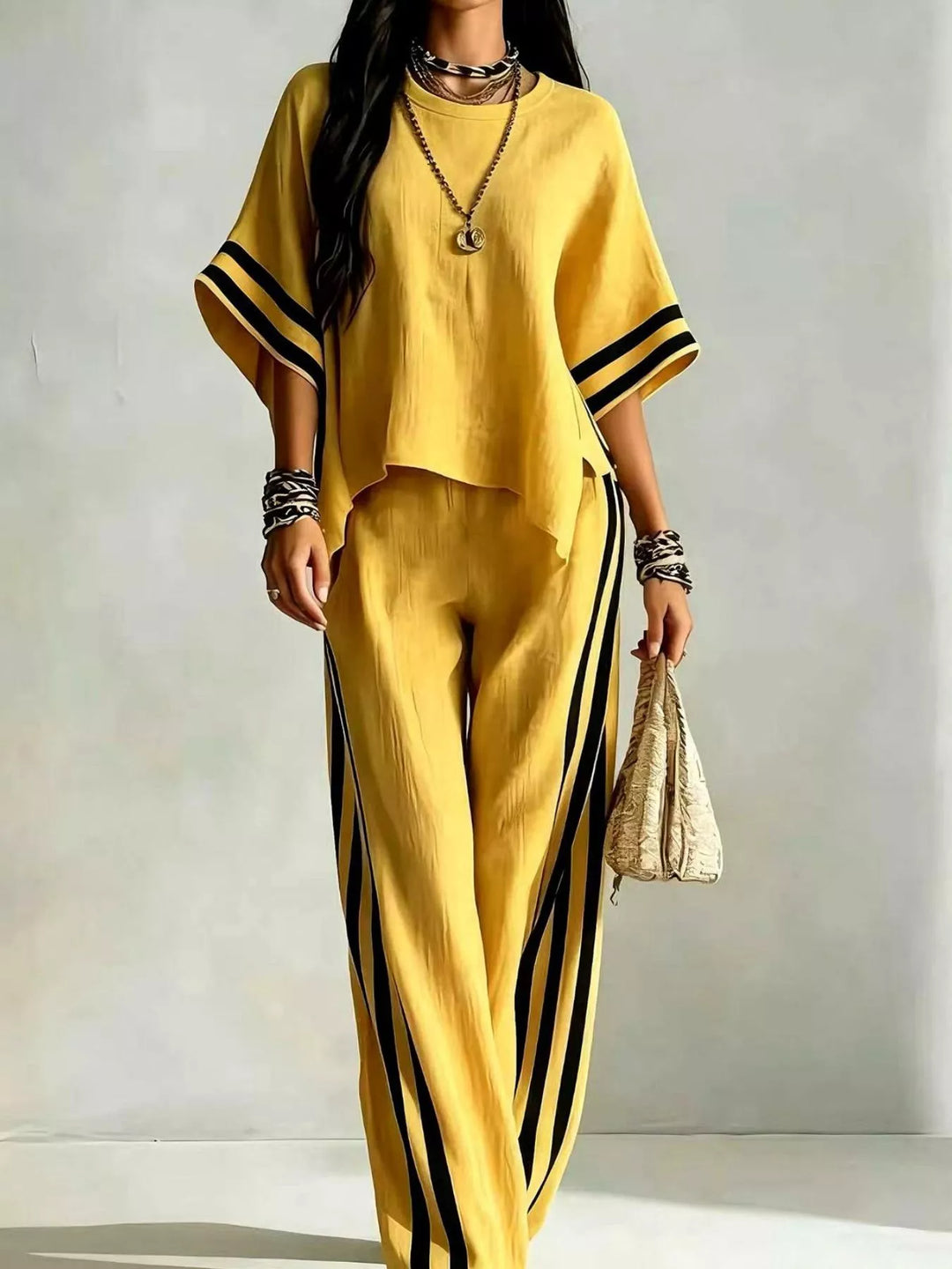 Yellow wide sleeve top with black striped wide leg pants, front view