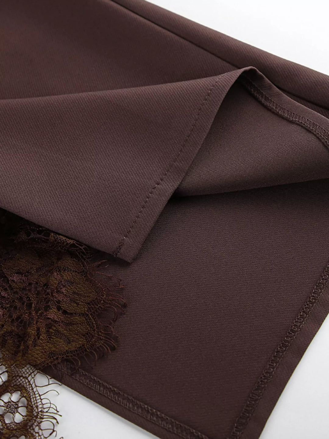 Chocolate brown skirt hem folded to show the scalloped lace edge