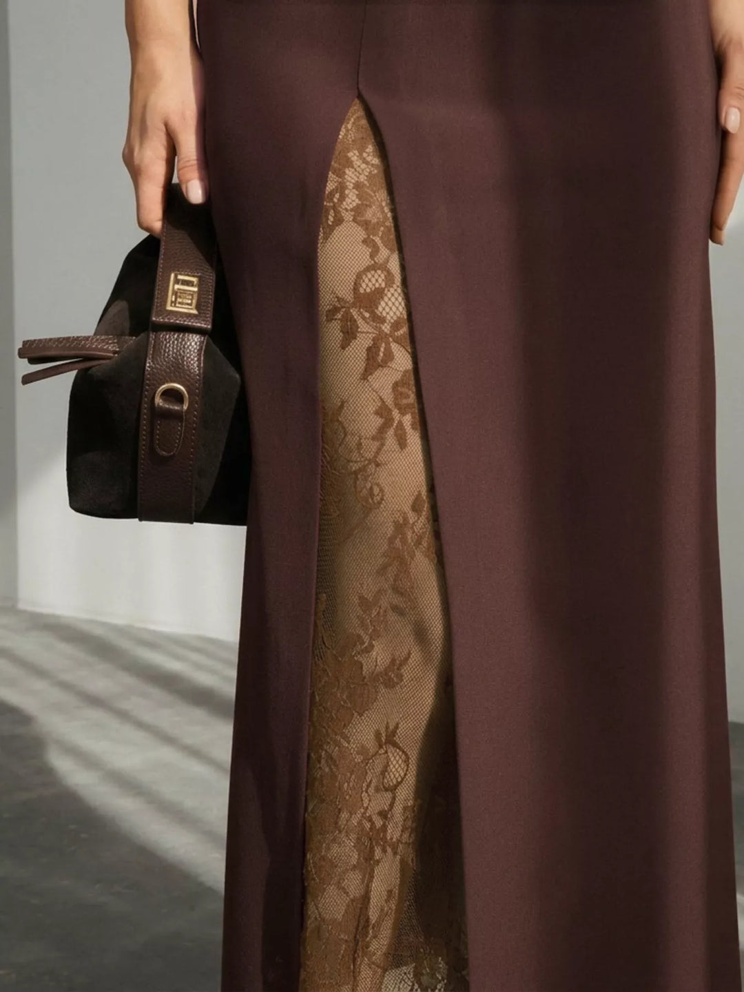Close-up of the lace trim showing through the front slit of the brown skirt