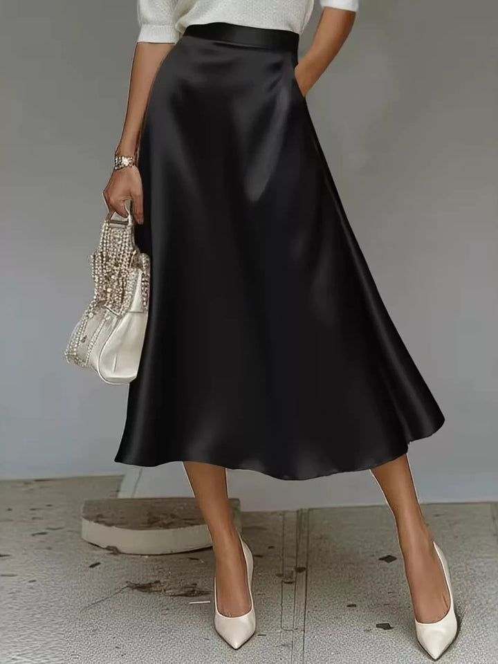 Black high waisted satin look A line midi skirt with a woven bag