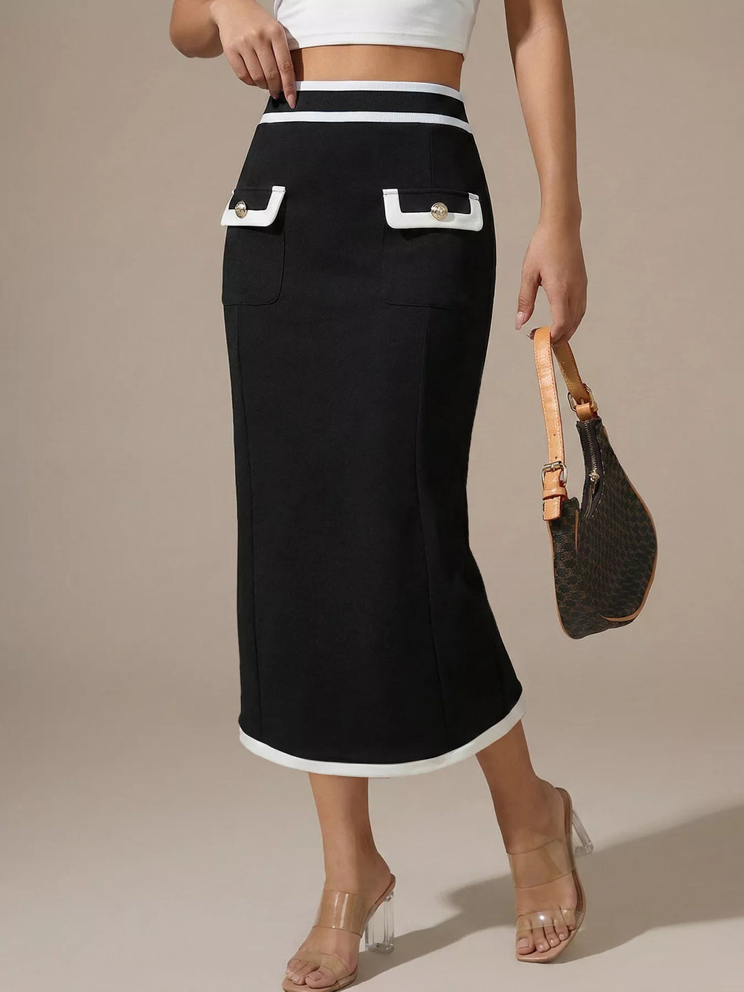 Black pencil midi skirt styled with a white crop top, clear heels and a bag