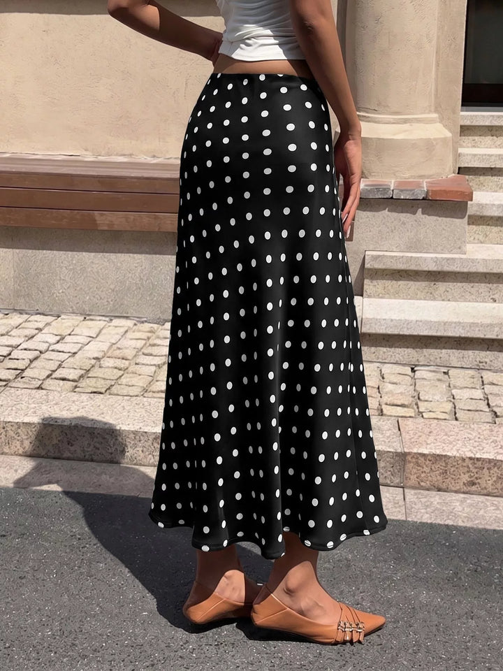 Back view of the black polka dot flared midi skirt on a sunny street