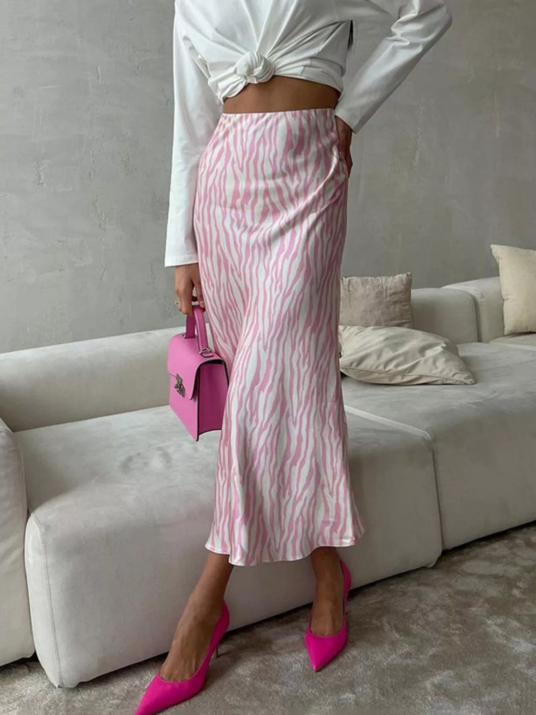 Light pink zebra print midi skirt with a white knotted top and pink heels