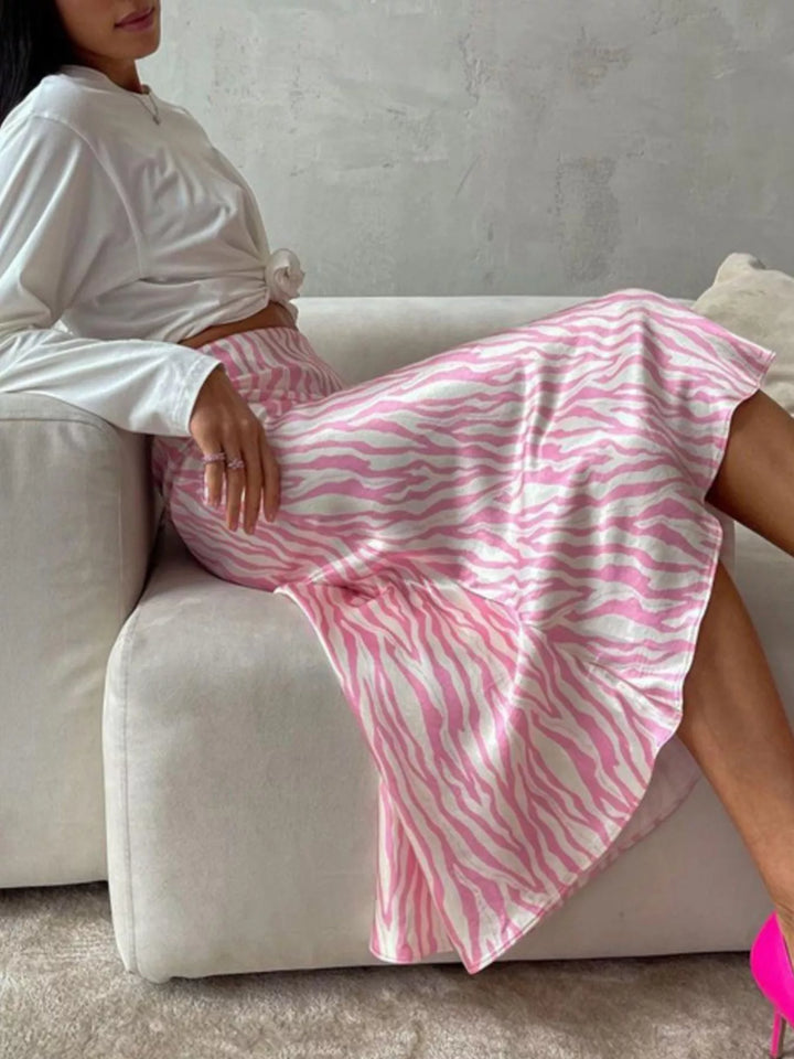 Light pink zebra midi skirt, seated on a cream sofa