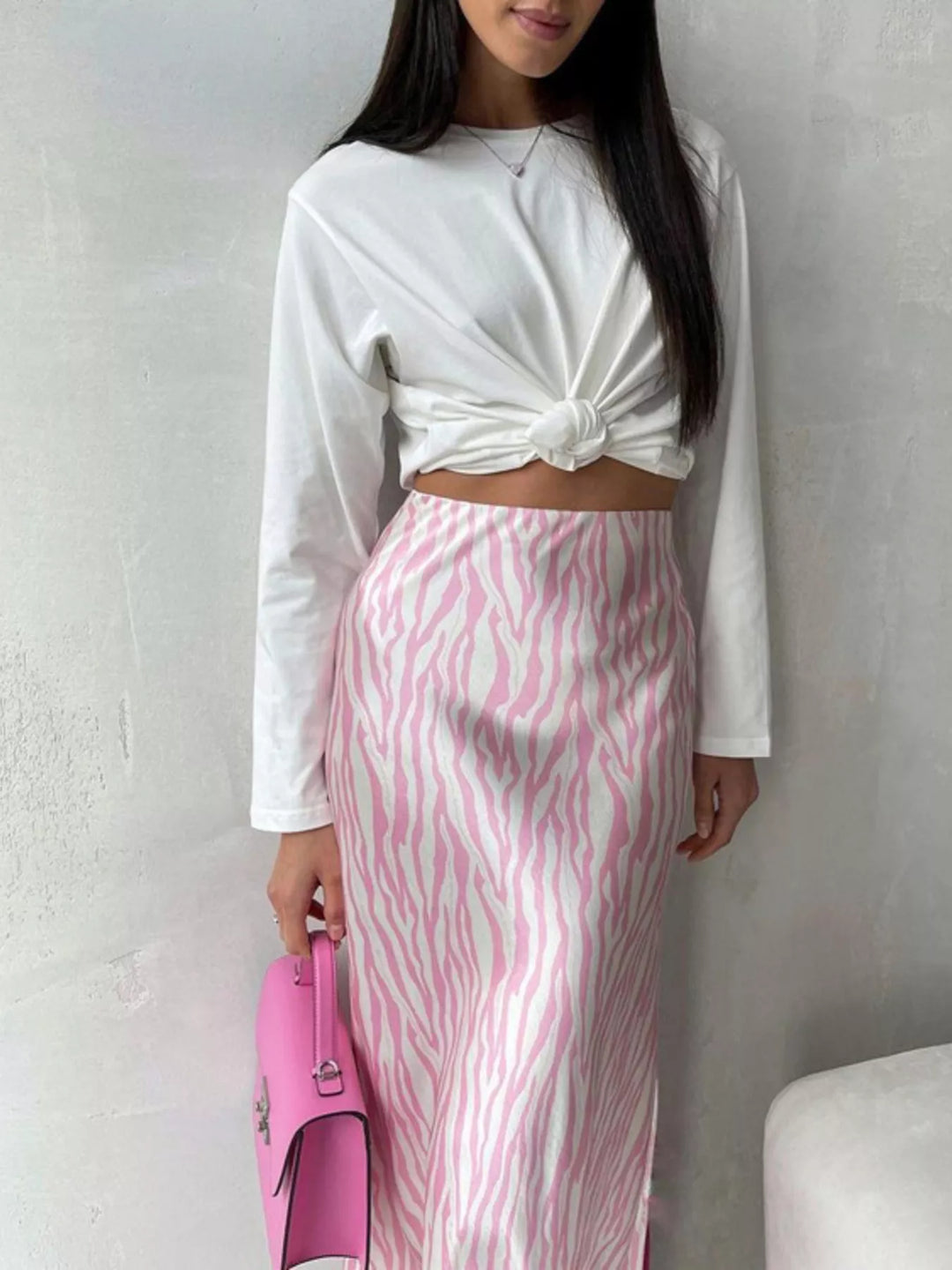 Light pink zebra skirt with a white knotted top, holding a pink purse