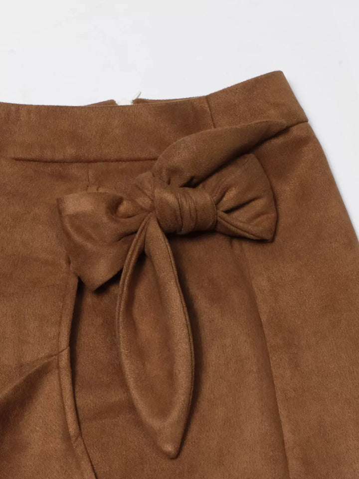 Close-up of the large bow tie on the camel brown wrap skirt