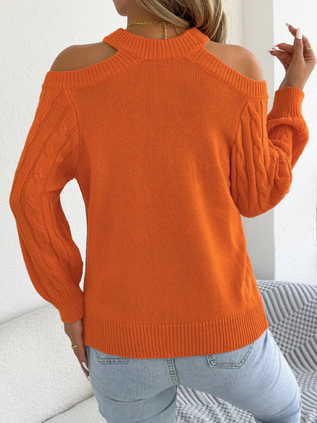 Back view of the orange mock neck sweater with cold shoulder cutouts