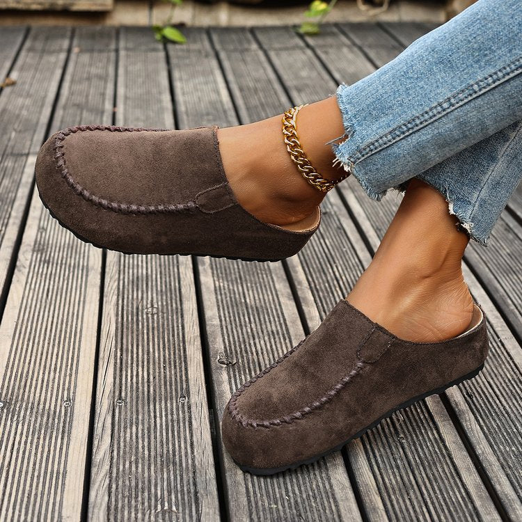 Side view of brown loafer style mules with stitched toe