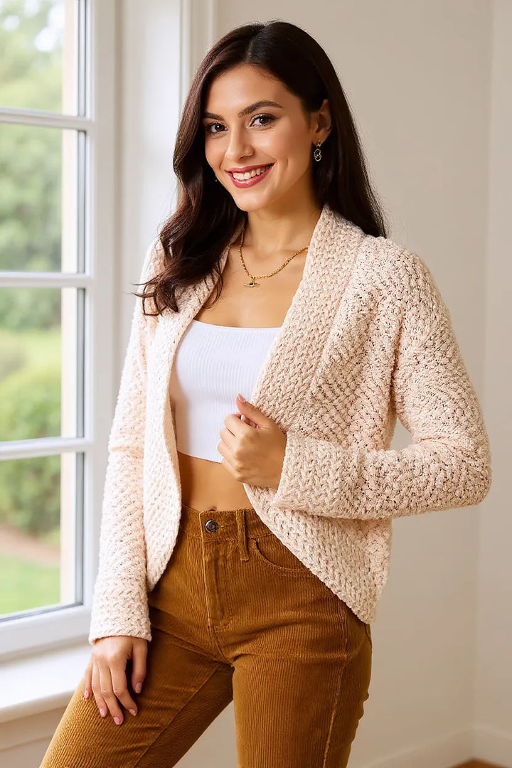 Women's open front cardigan in cream, cropped popcorn knit, smiling by a window
