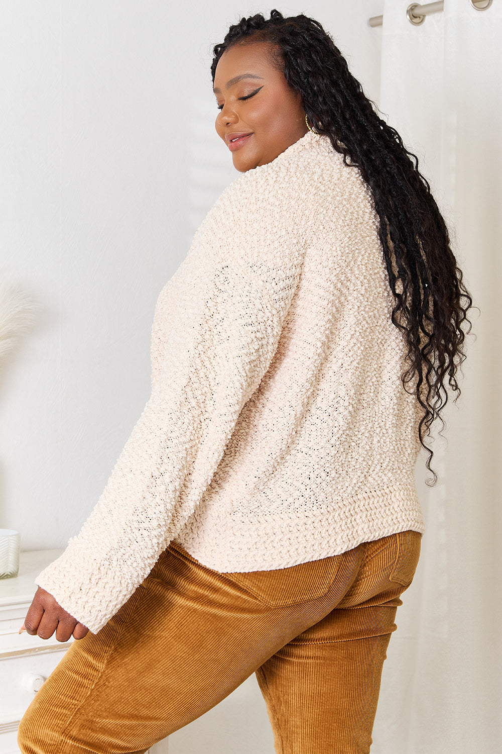 Side view of the cream popcorn knit cardigan on a plus size model