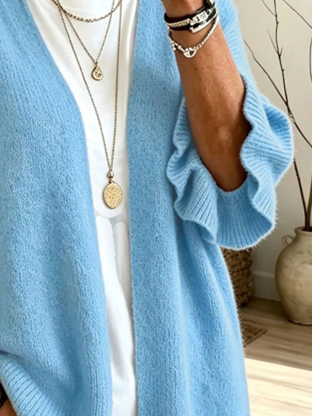 Close-up of the light blue cardigan front edge and ruffle cuff
