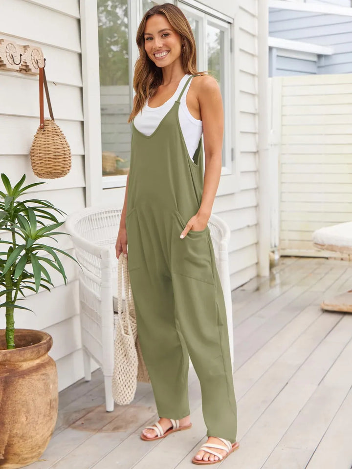 Matcha green wide strap overalls styled with a white tank, smiling pose