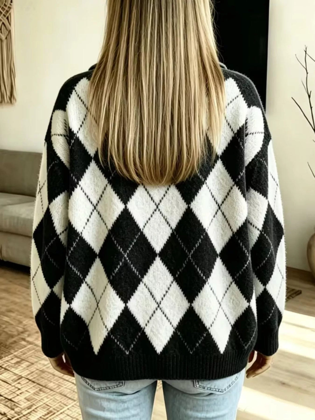 Back view of the black argyle sweater with diamond pattern, worn with jeans