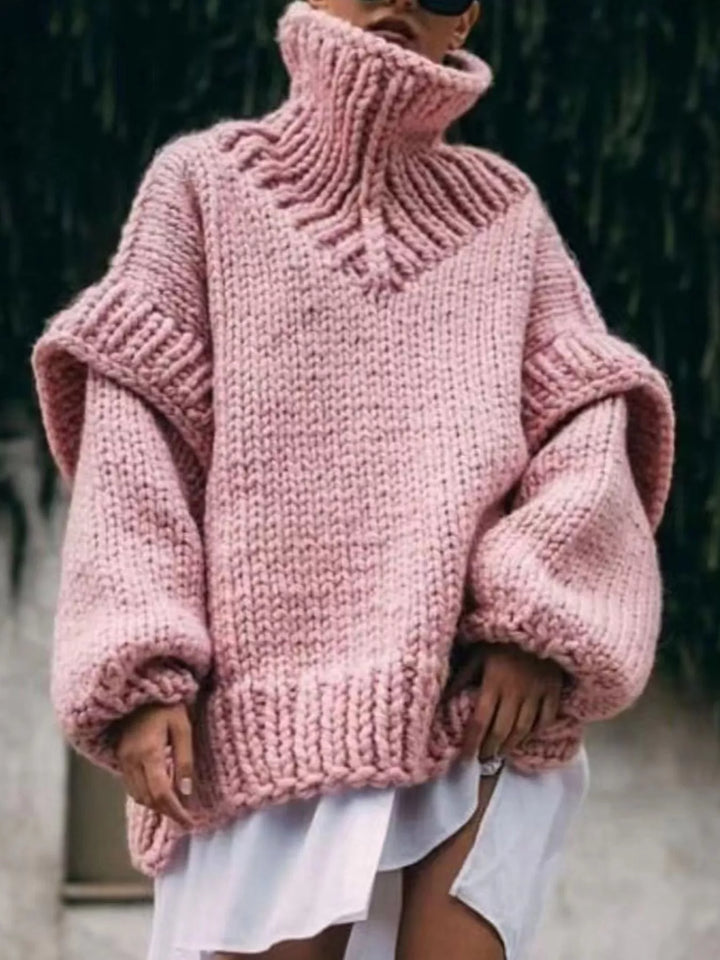 Pink chunky turtleneck sweater with layered shoulders and a ribbed hem