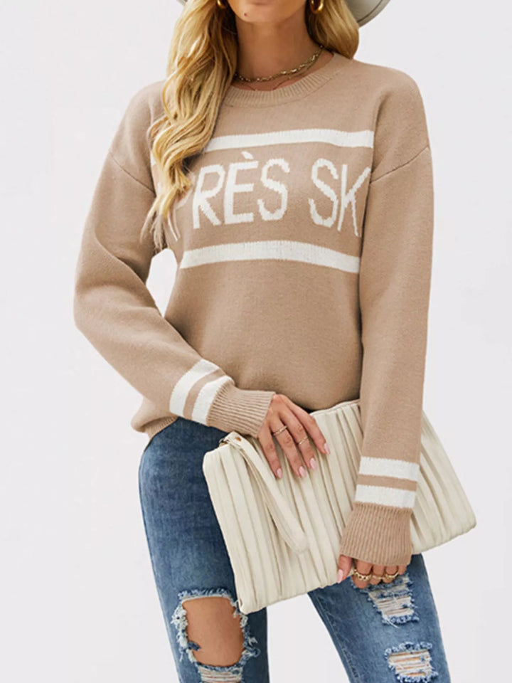 Taupe slogan sweater with a cream clutch and striped cuff detail