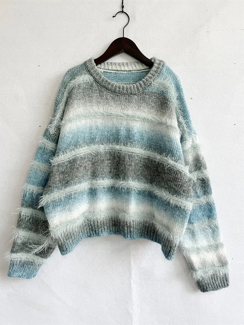 Teal blue striped round neck sweater hanging on a hanger