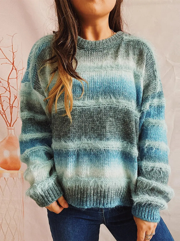 Teal blue striped oversized sweater worn with jeans, front view